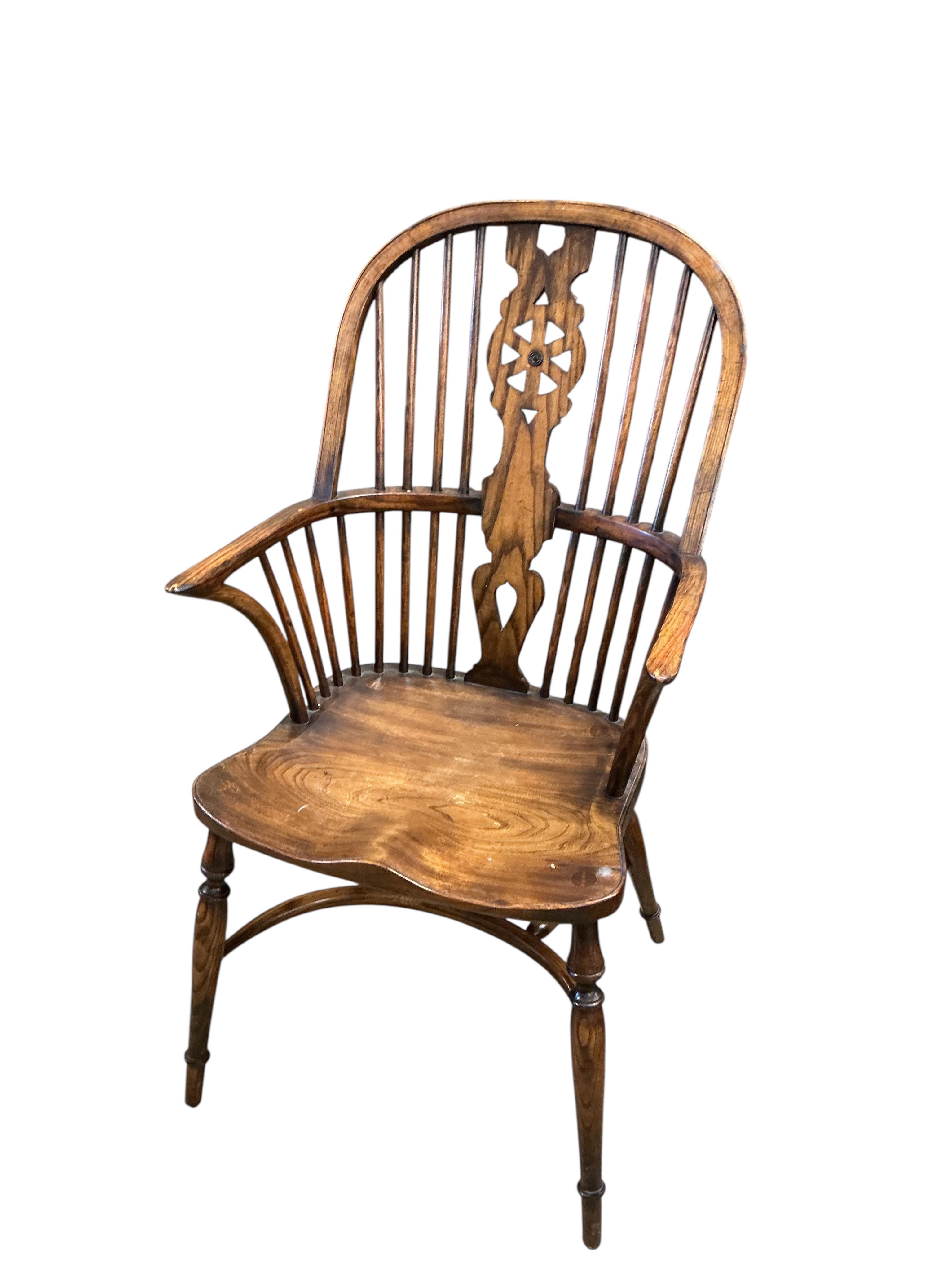 A set of ten reproduction Windsor elm and beech dining chairs with pierced splats and crinoline stretchers, two with arms